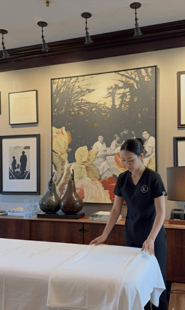 Knead NYC massage therapist preparing table for luxury in-room massage at Manhattan hotel