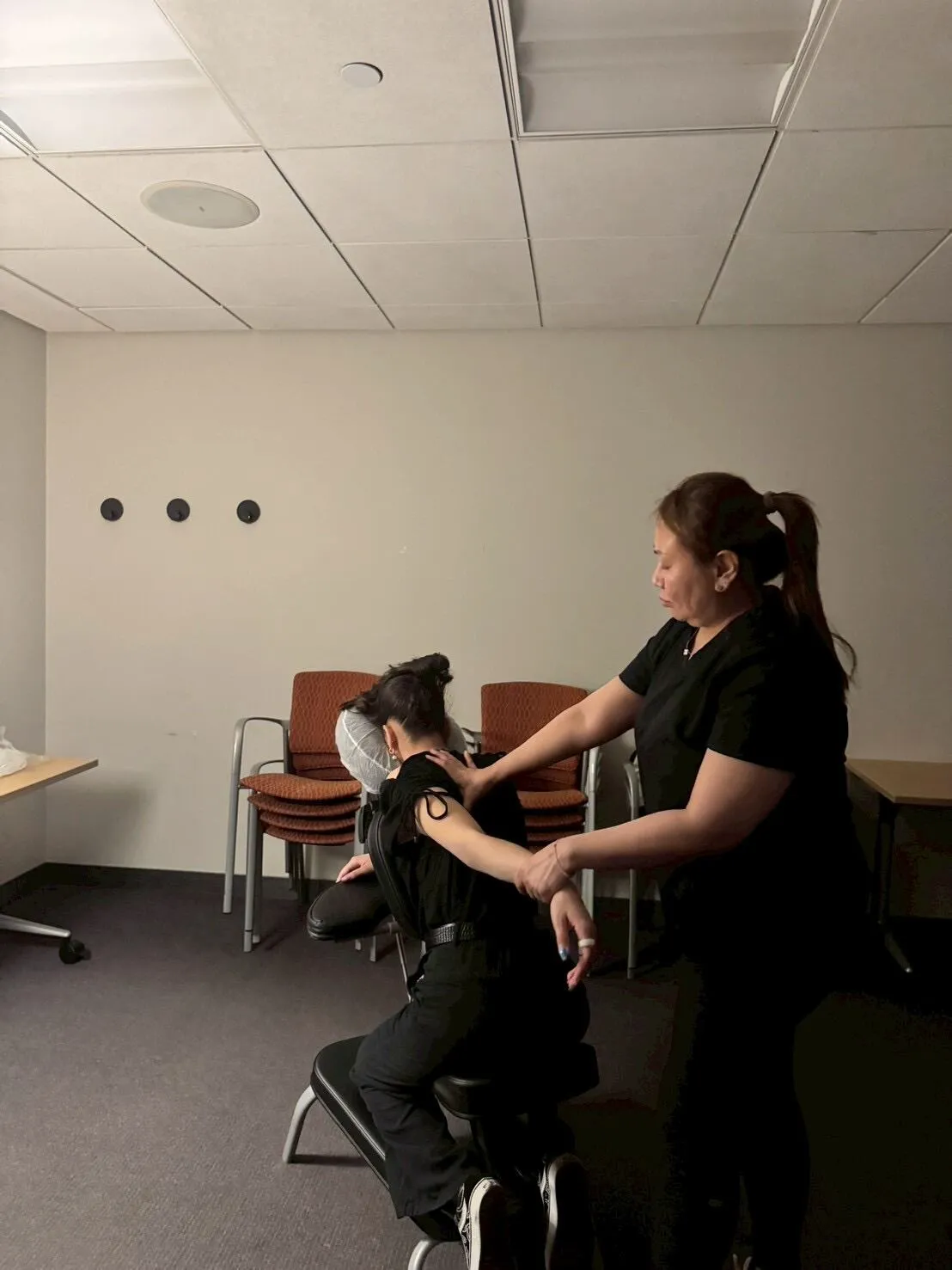 Employee receiving an on-site chair massage in an office meeting room