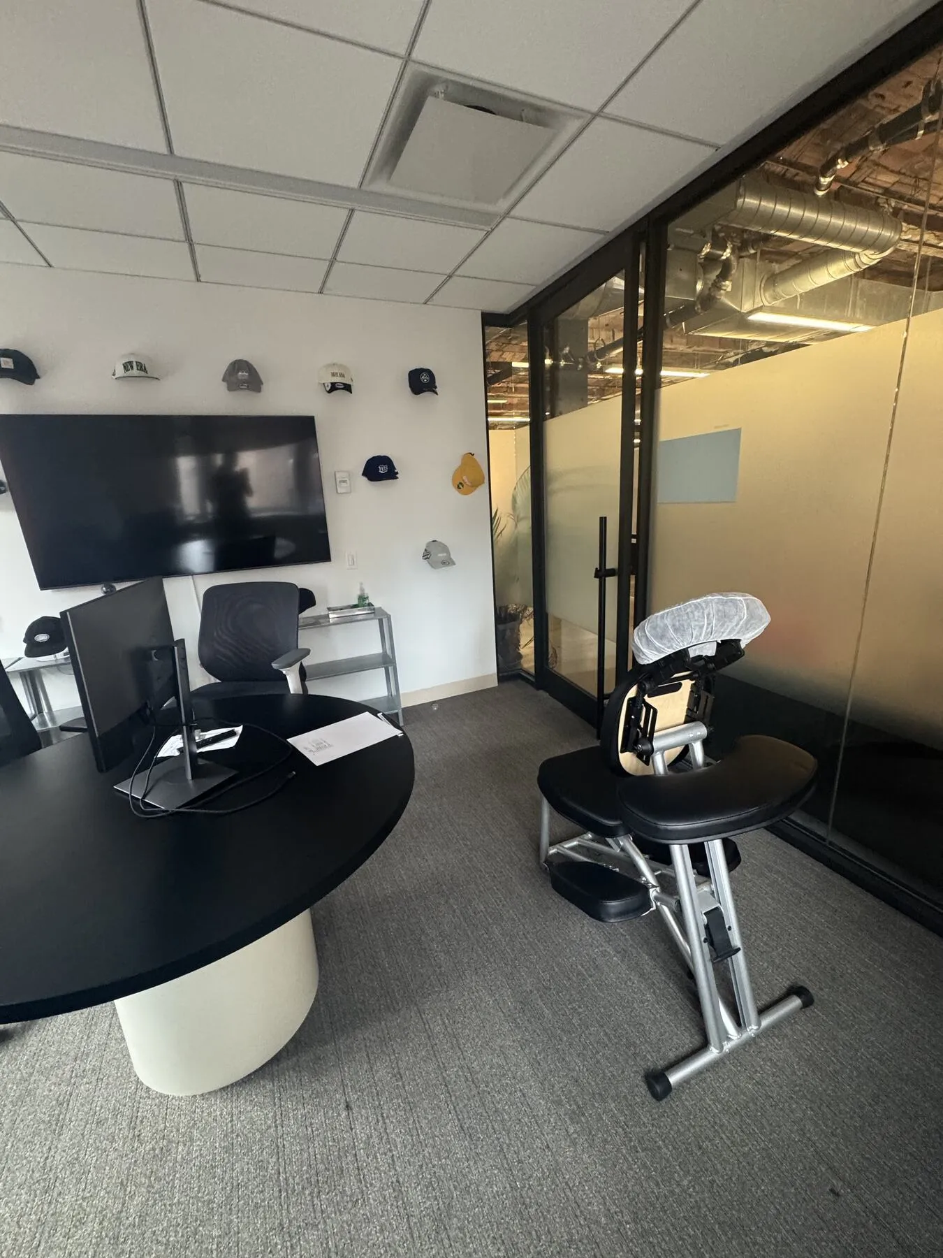 Portable chair massage station set up in a glass-walled office meeting room
