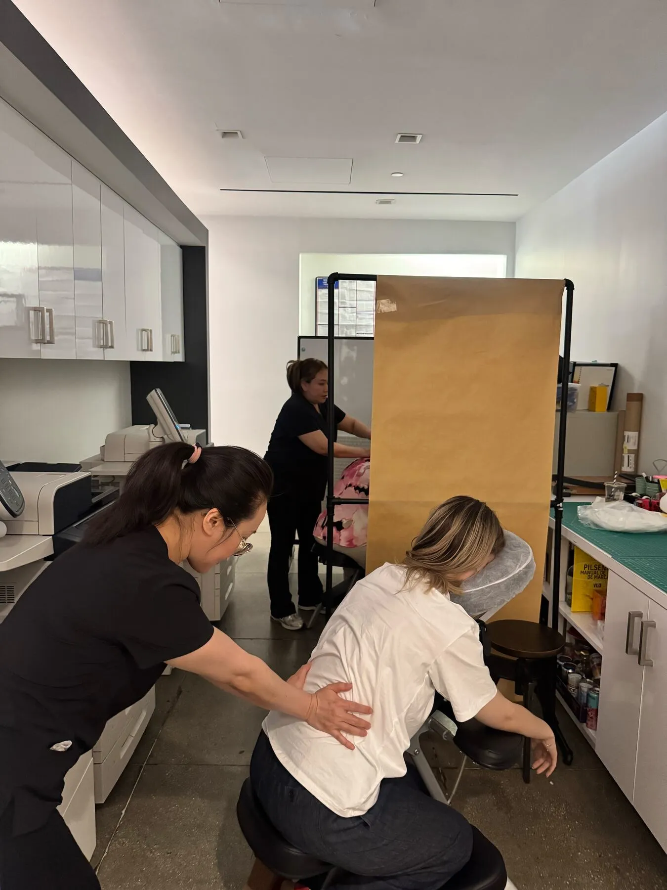 Two Knead NYC therapists providing chair massages at an office wellness event