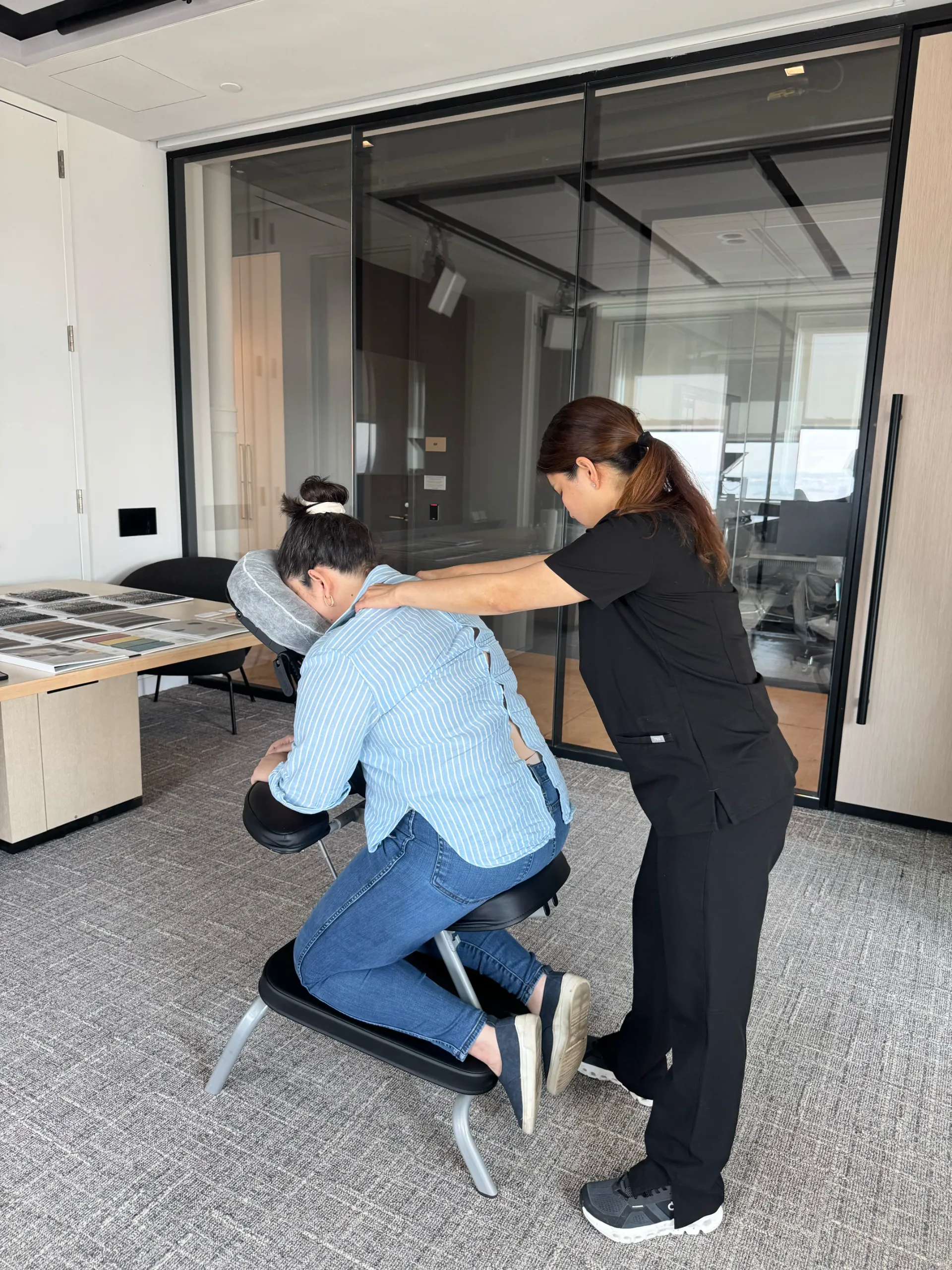 Home - In-Home Massage NYC 4 Knead NYC therapist providing chair massage to a client in a corporate office