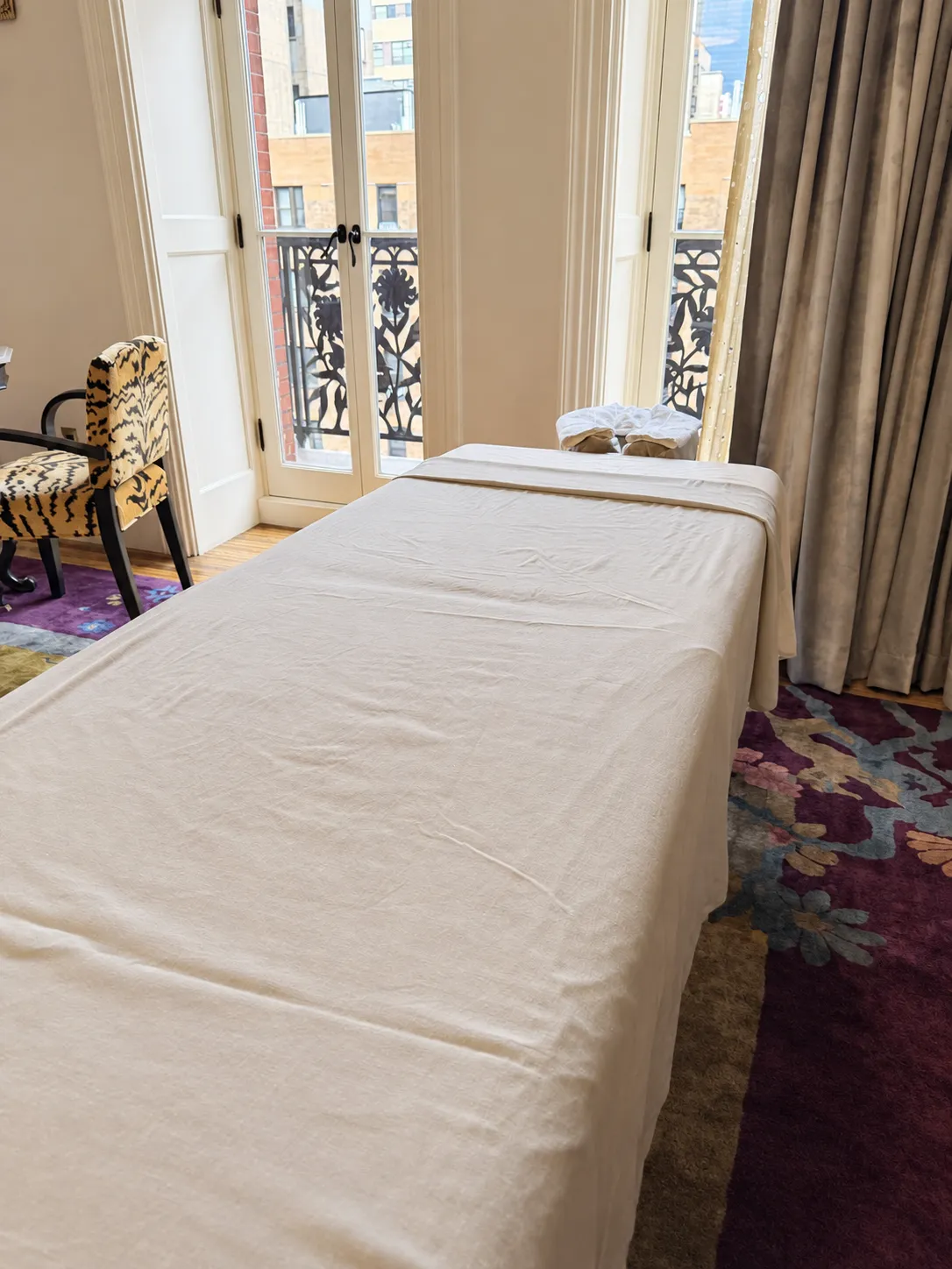 Knead NYC massage table prepared beside French windows in a private room